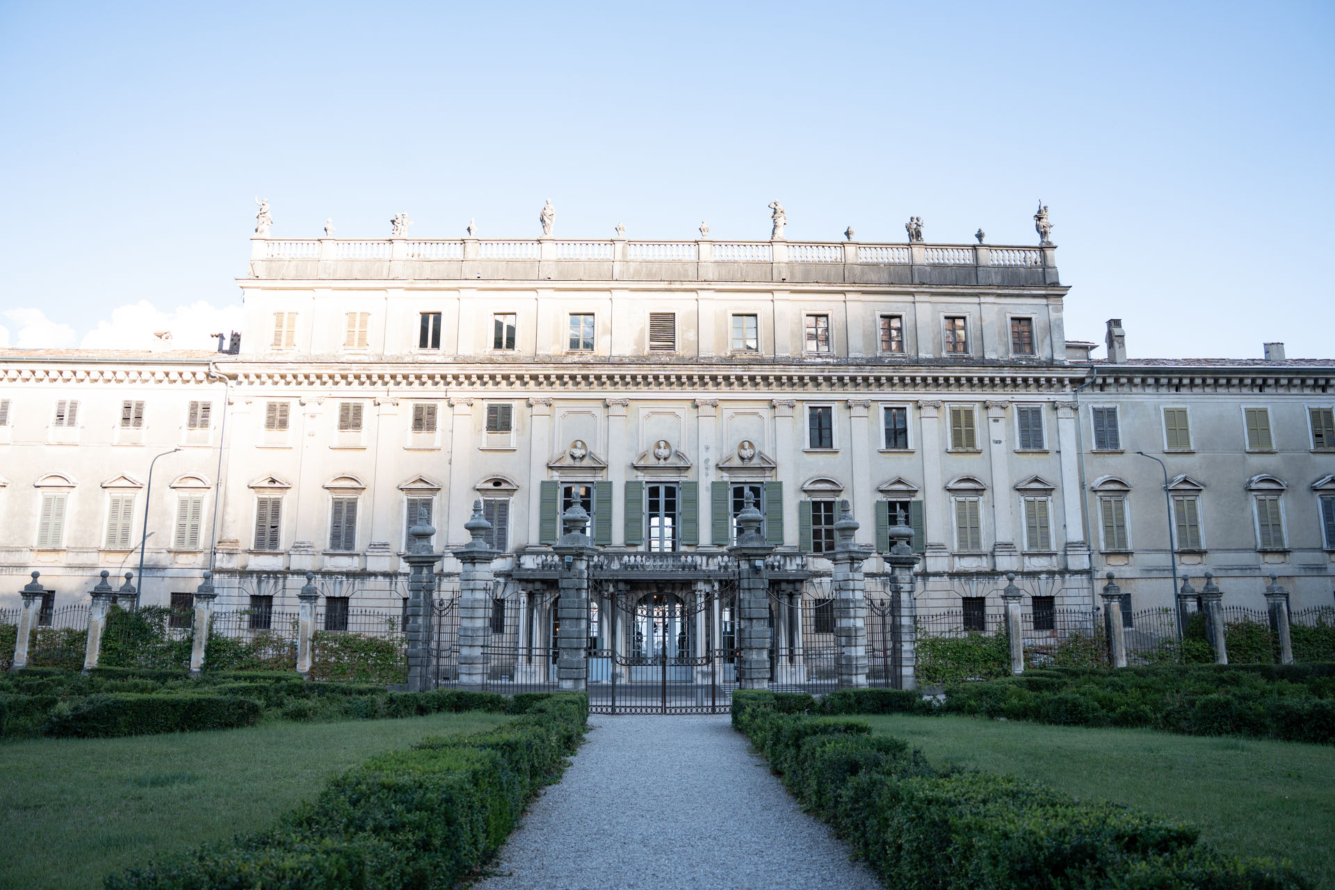 A magnificent neoclassical villa in Tuscany with a central gate and a symmetrical facade.