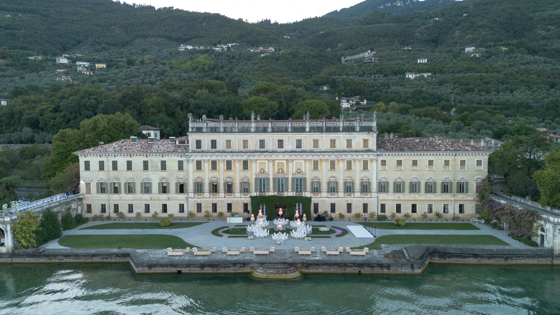 Luftaufnahme einer Villa mit einer Hochzeitsdekoration im Freien am Ufer des Comer Sees.