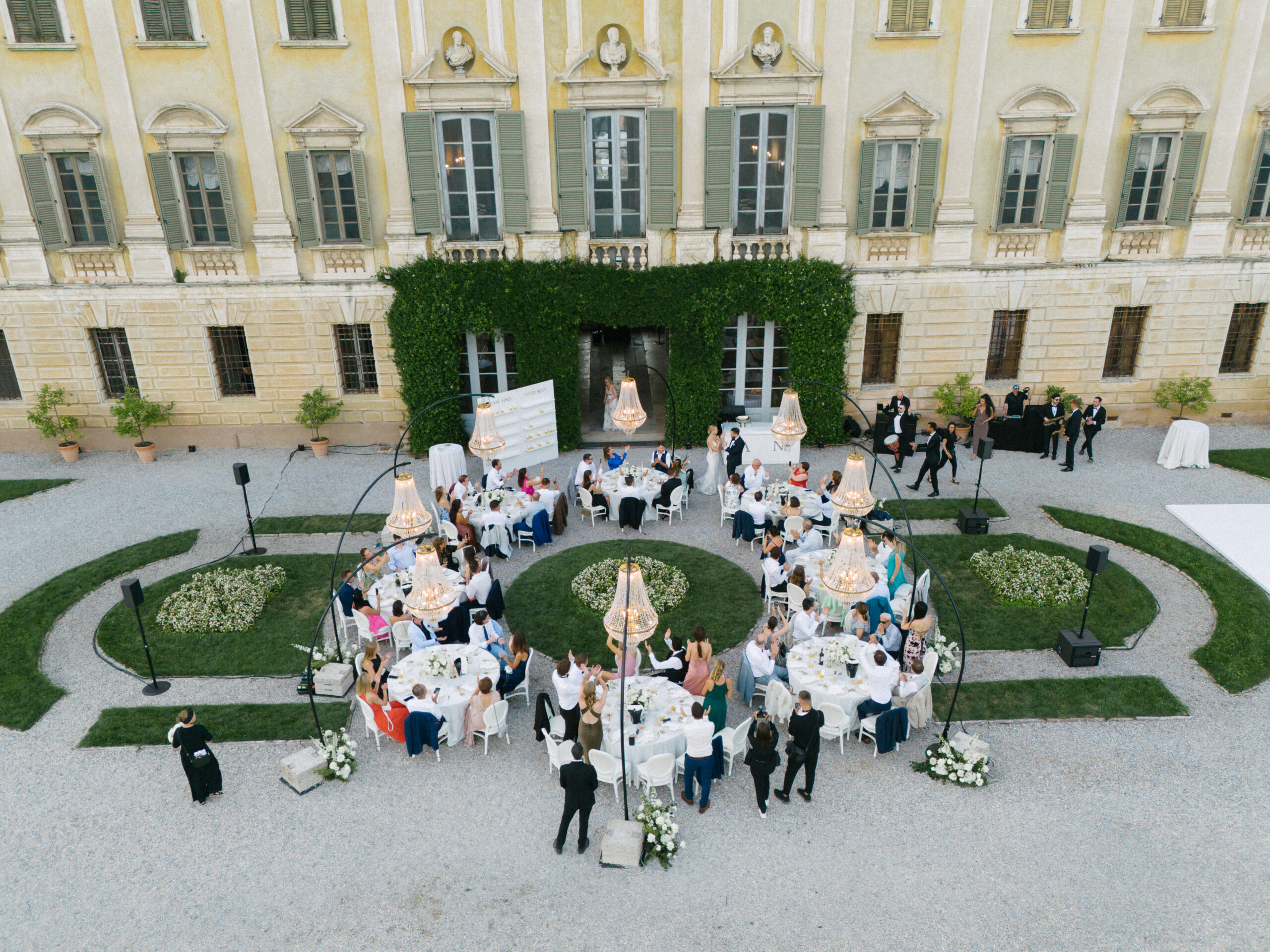 Luftaufnahme der Hochzeitsgäste an runden Tischen in einer italienischen Villa am Comer See.
