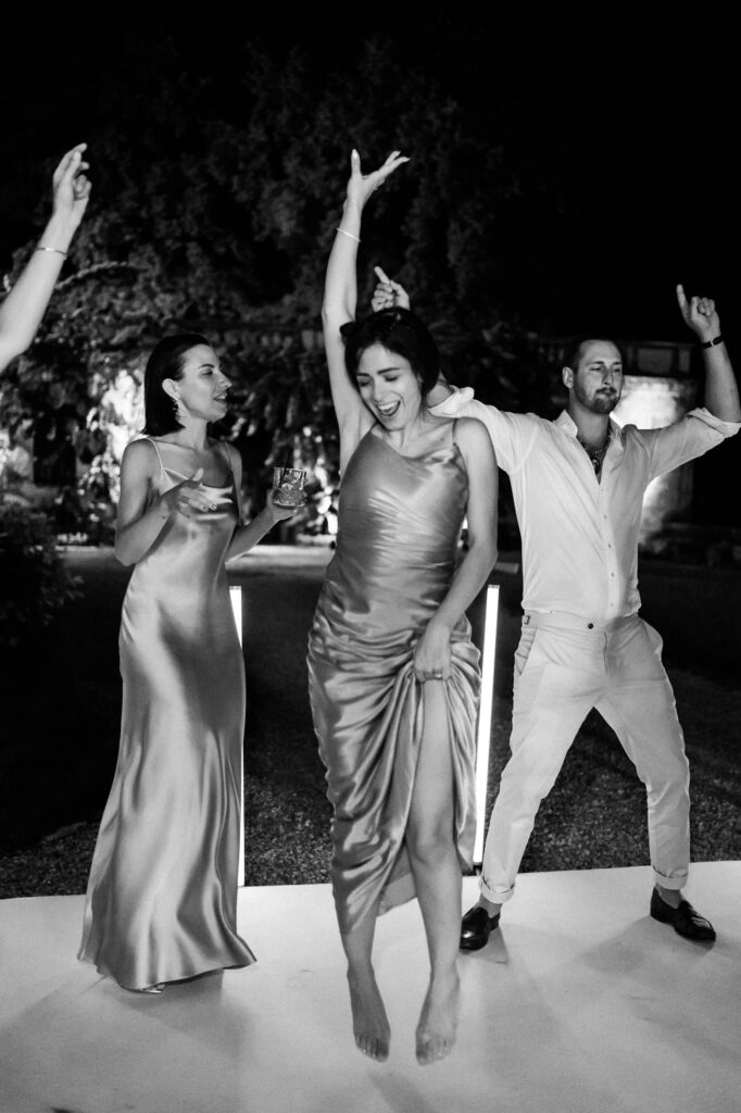 Brautpaar und Gast tanzen ausgelassen bei einer Hochzeit in der Villa Bettoni in Italien.